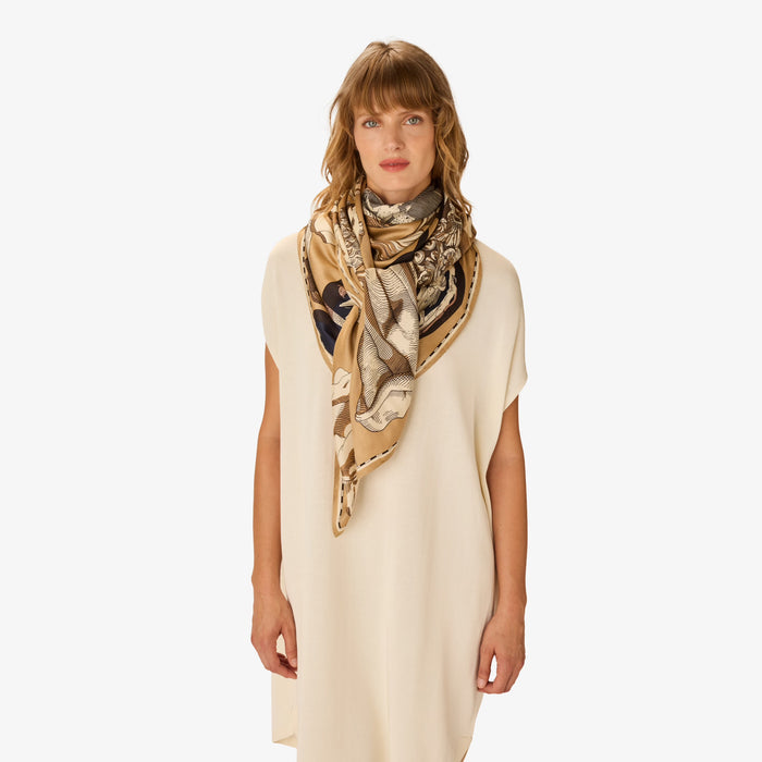 Woman wearing a beige scarf with a pattern on a white background