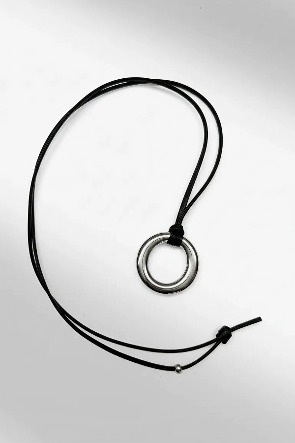 Necklace with a circular pendant on a light gray background | Exclude | Still