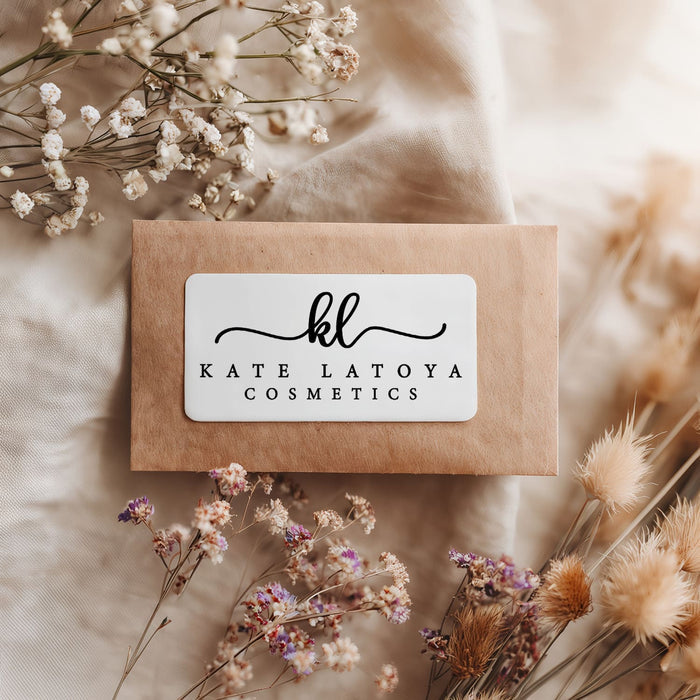 Kraft envelope sealed with rectangular black print branding sticker featuring script initials and serif text design – XOXOKristen.