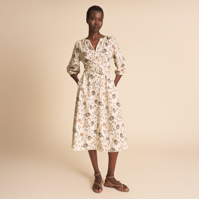 Woman wearing a floral dress on a beige background | Lead