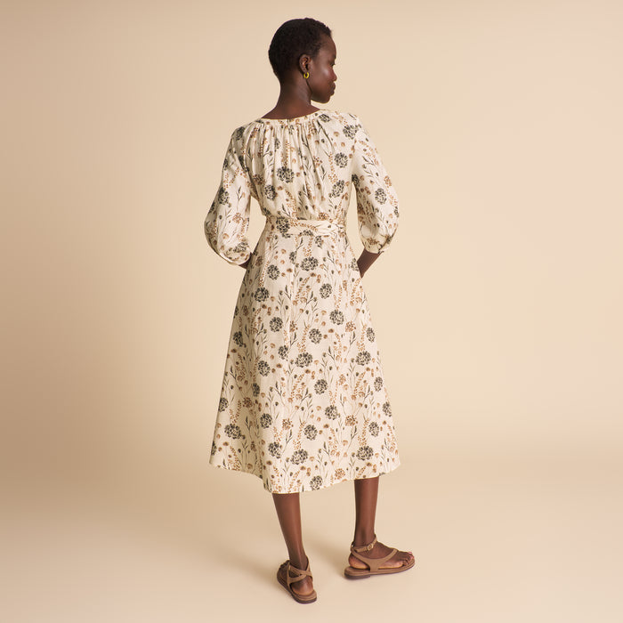 Woman wearing a floral dress on a beige background