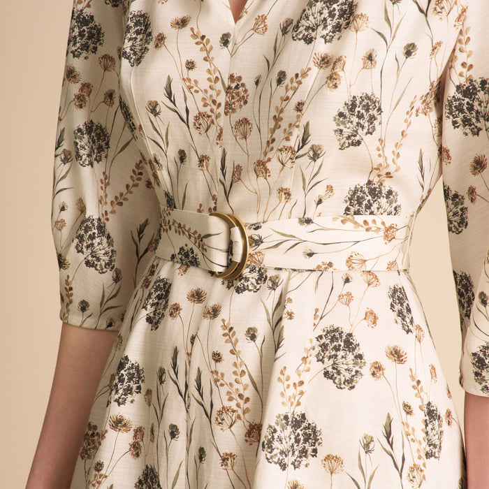 Floral patterned dress with a belt on a beige background